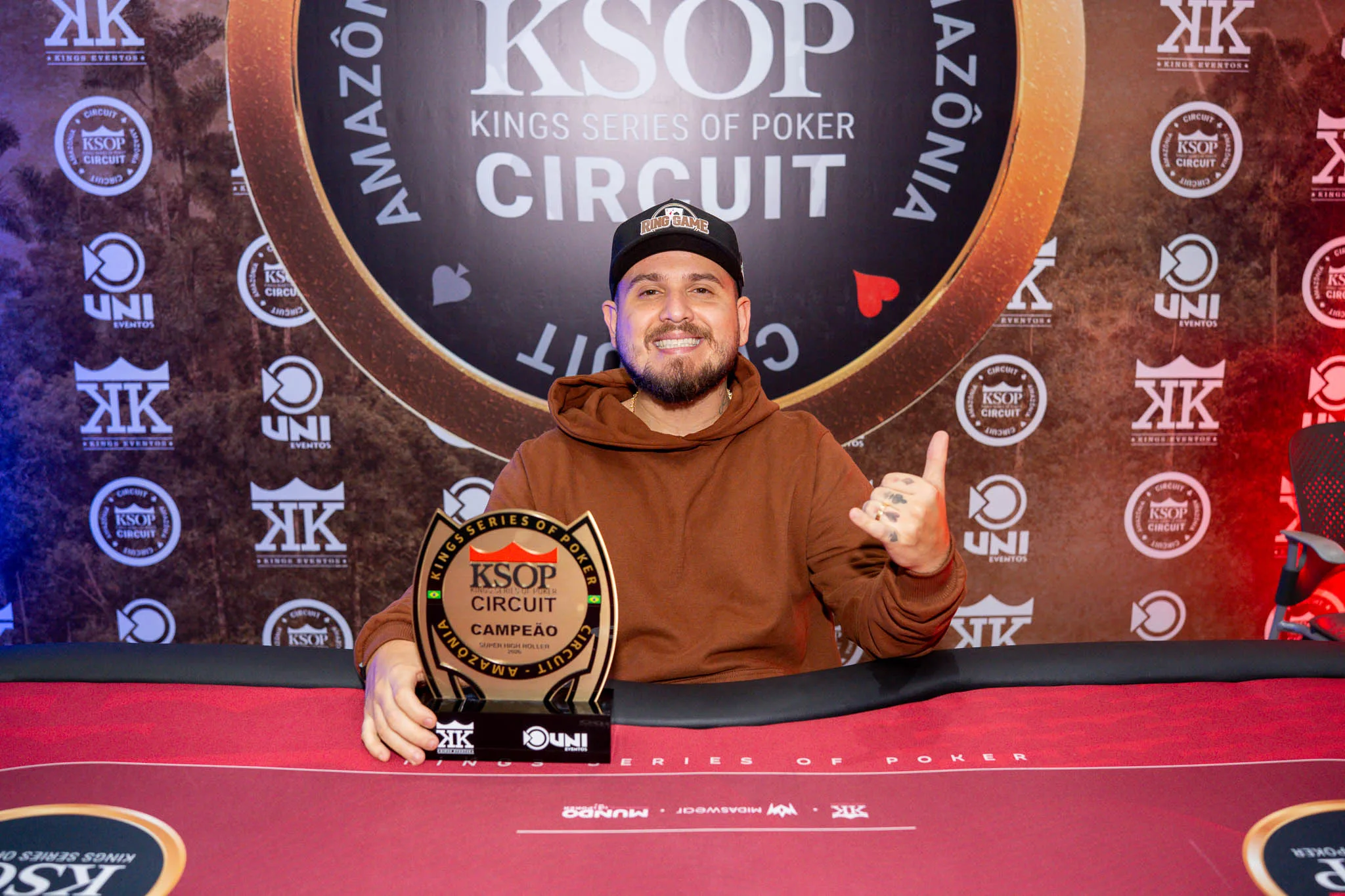 Three poker players celebrating their tournament victories at a poker table with chips and cards