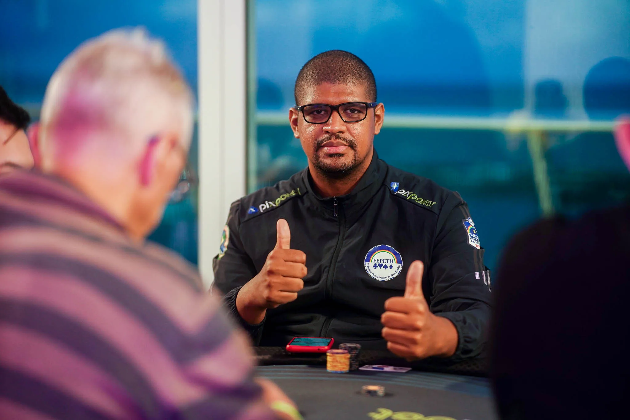 Poker chips and cards on a poker table at the NPS Pixbet Recife event