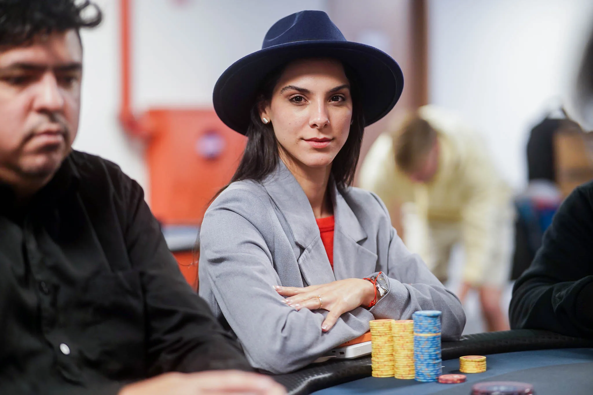 Poker players in action at a tournament, with chips and cards visible.