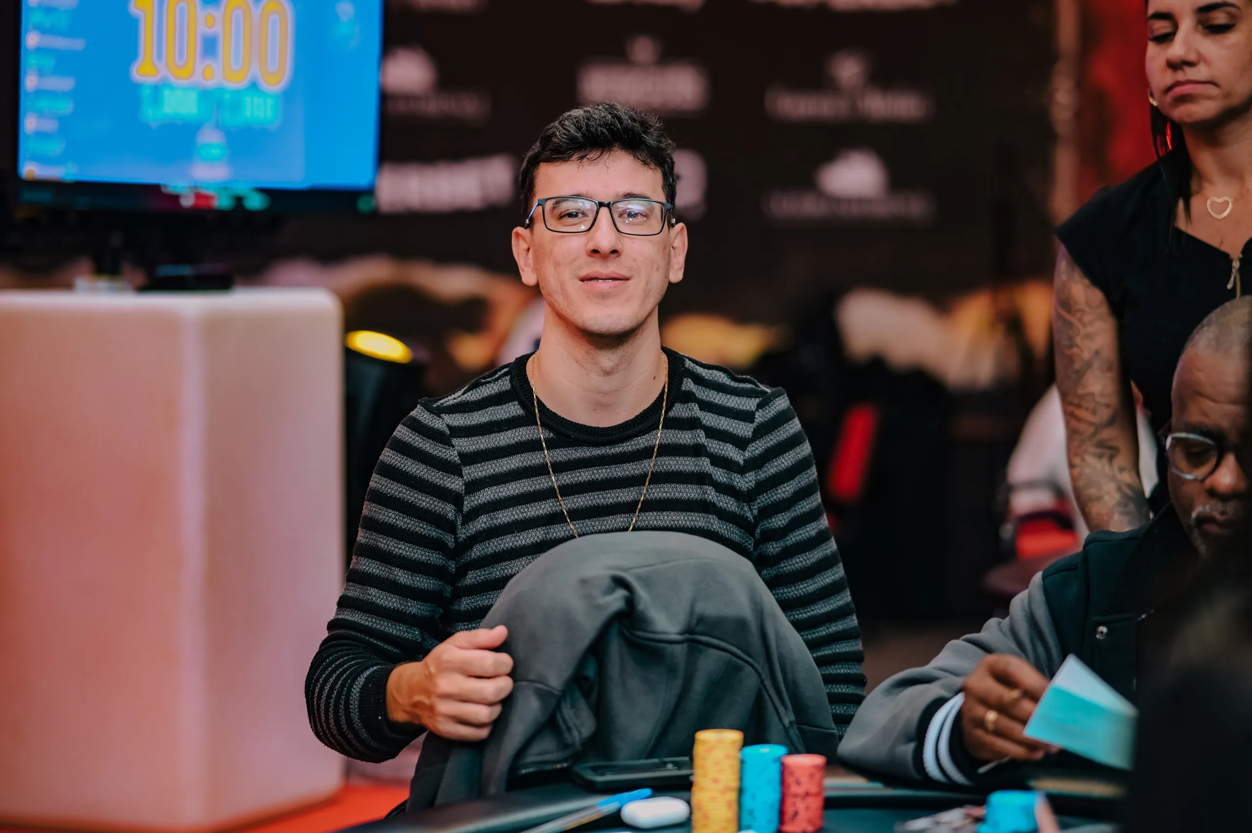 Daniel Noronha, a professional poker player, seated at a poker table with a large stack of chips.