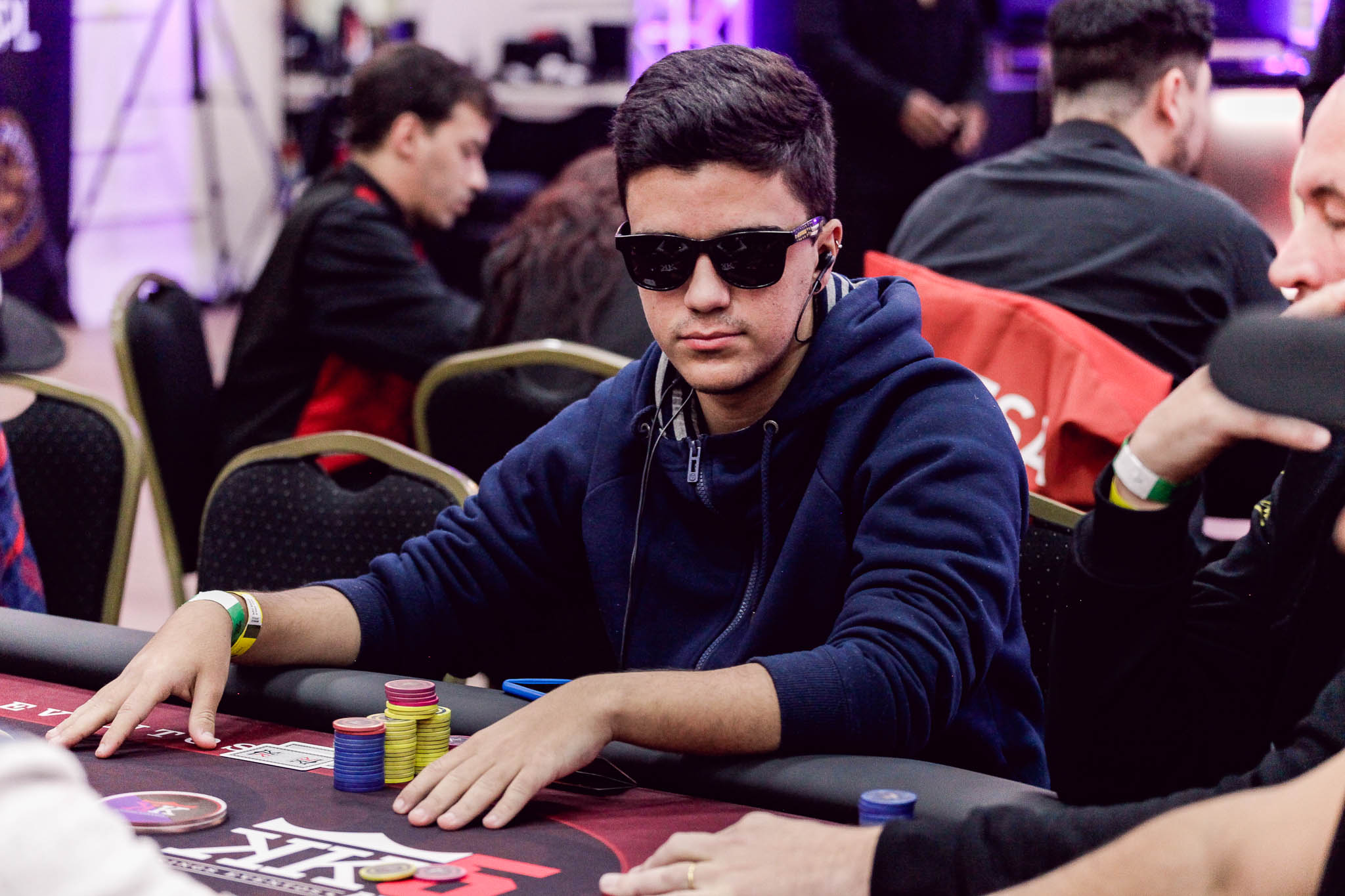 Professional poker players at a final table during a tournament.