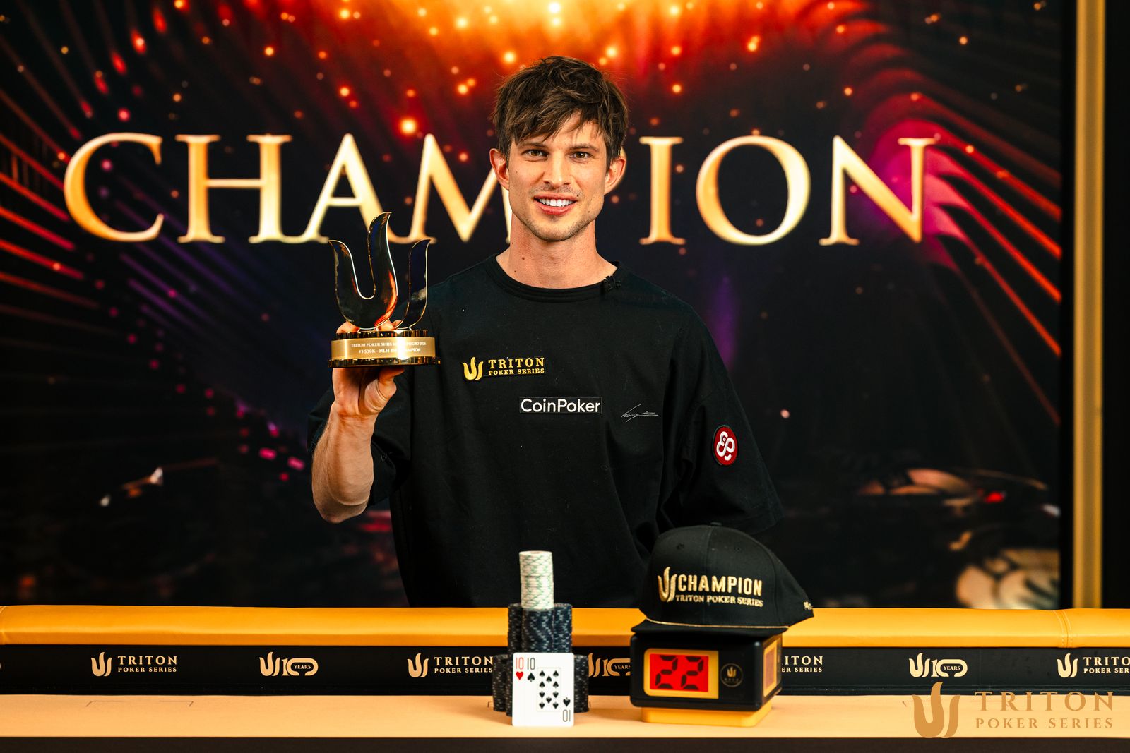 Mario Mosböck celebrating his win at the Triton Super High Roller Series in Montenegro with poker chips and trophy