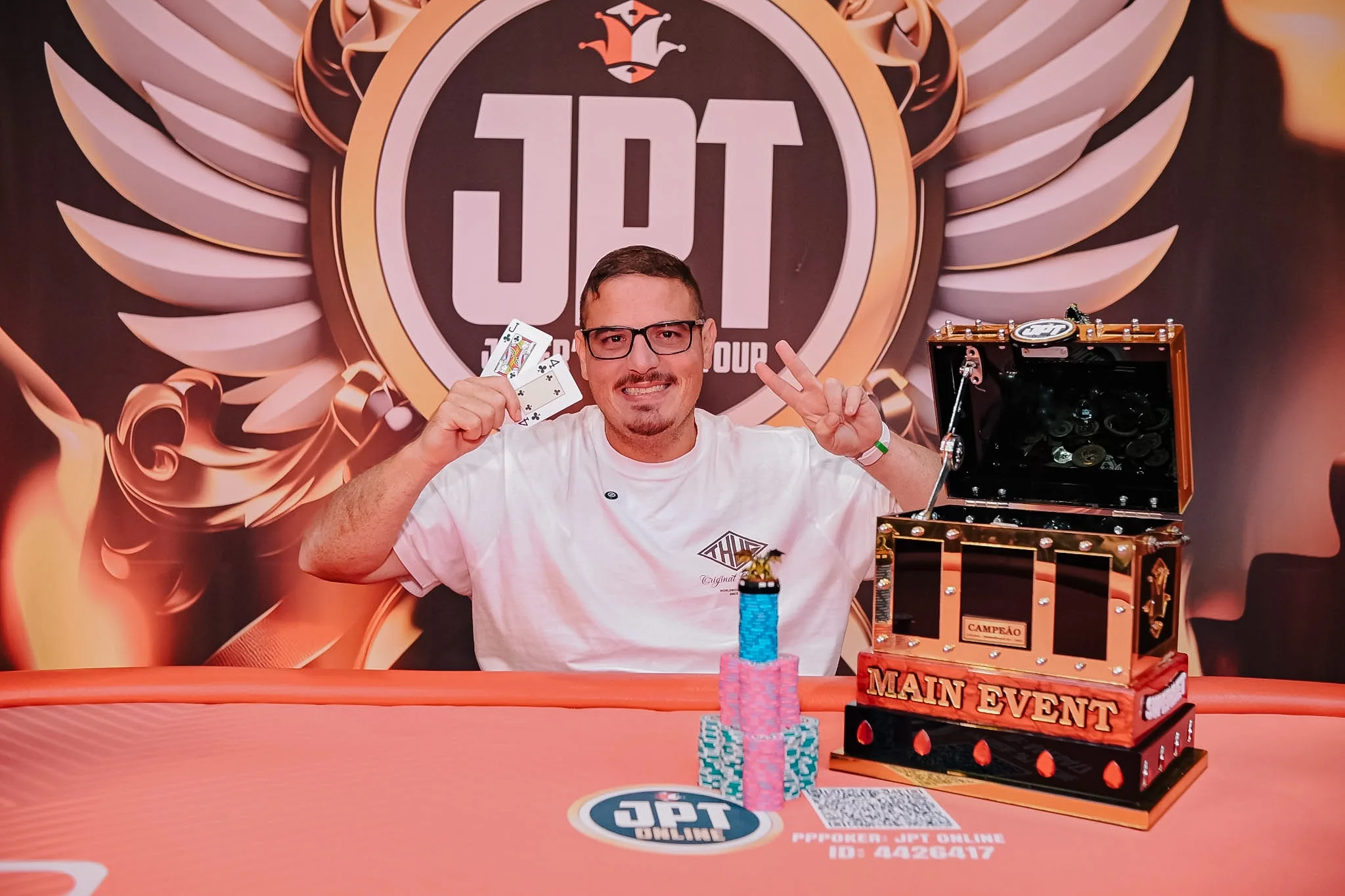 Rodrigo Gil, winner of the JPT Main Event, holding his trophy and smiling.