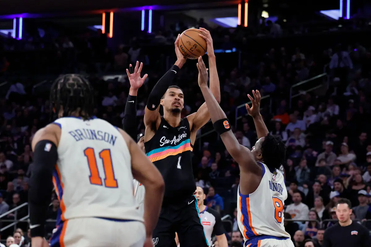 Two basketball teams, the New York Knicks and the San Antonio Spurs, facing off on a basketball court during an NBA Finals game.