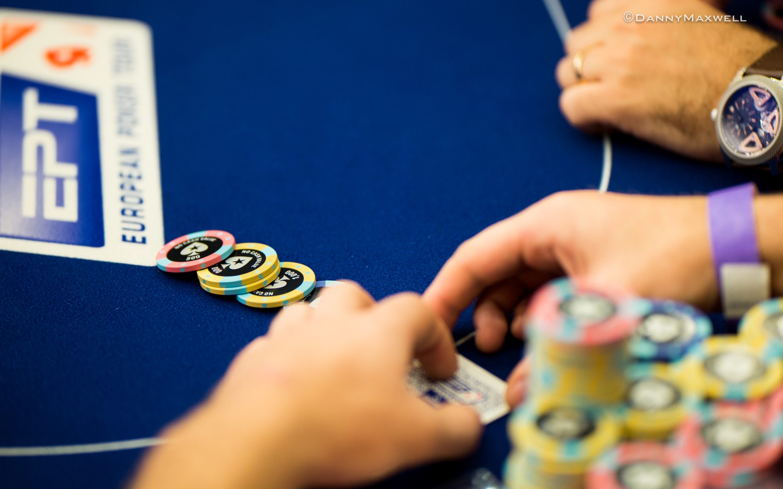 Poker player studying hand history on a tablet at a live tournament table