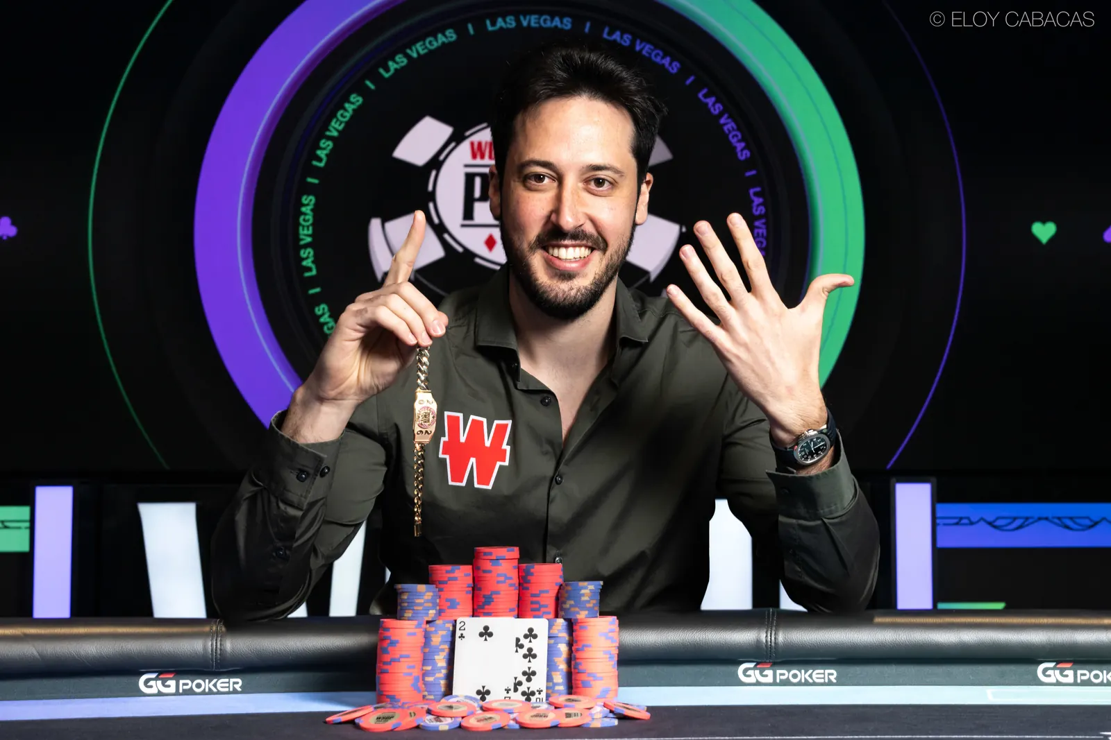 Adrian Mateos smiling and holding up his sixth World Series of Poker bracelet after winning the $250,000 Super High Roller.