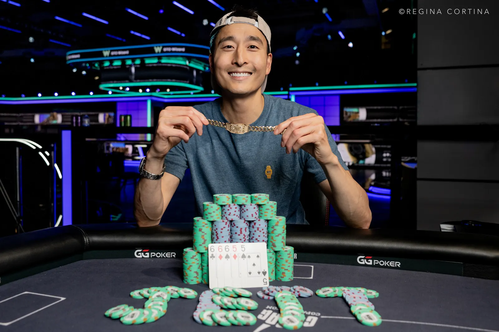 Taylor Atchison smiling and holding a World Series of Poker gold bracelet.