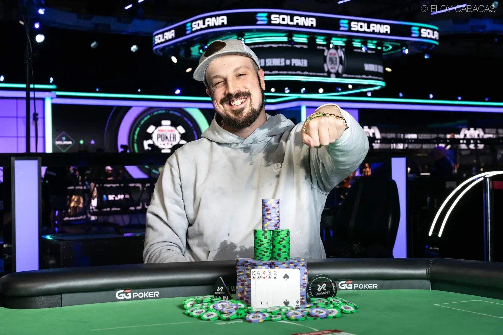 A golden World Series of Poker bracelet resting on a green poker table felt.