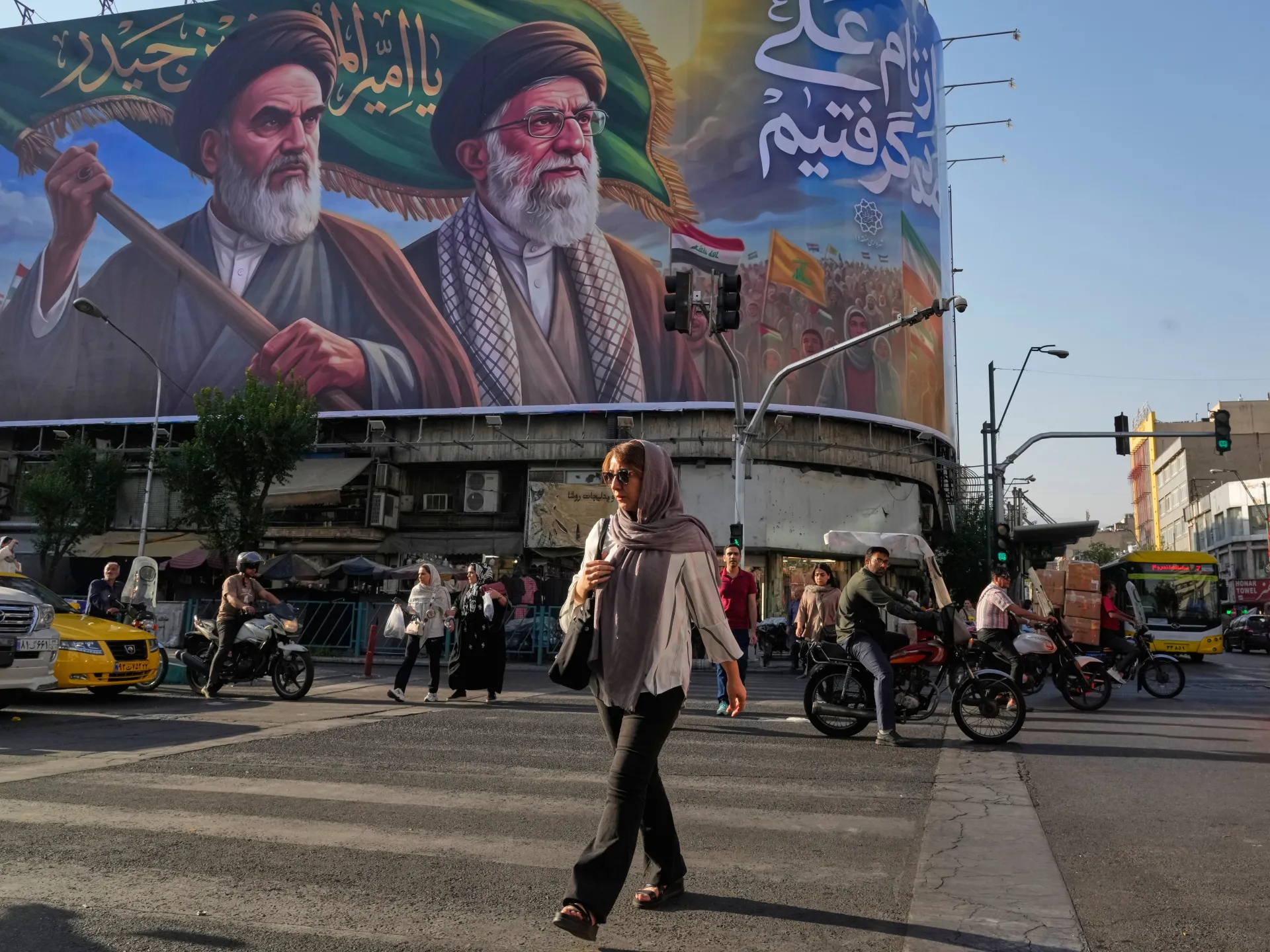 Flags of Lebanon and Iran with a blurred background of regional conflict imagery.