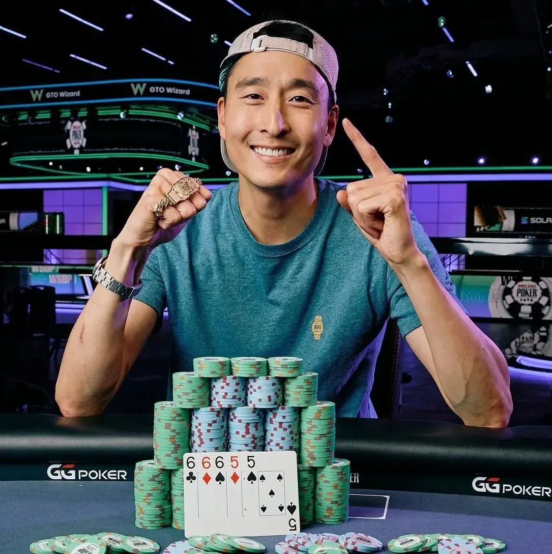 Taylor Atchison holding up a WSOP bracelet and smiling.