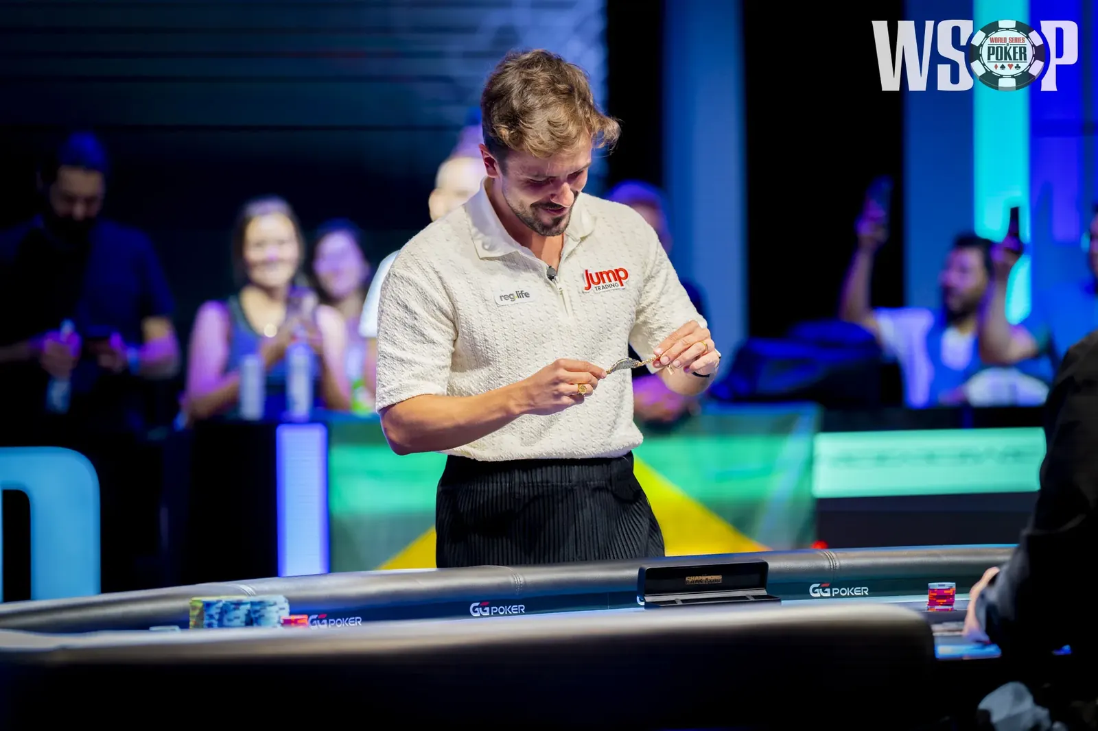 Professional poker players Yuri Dzivielevski and Nick Schulman holding up their World Series of Poker bracelets.
