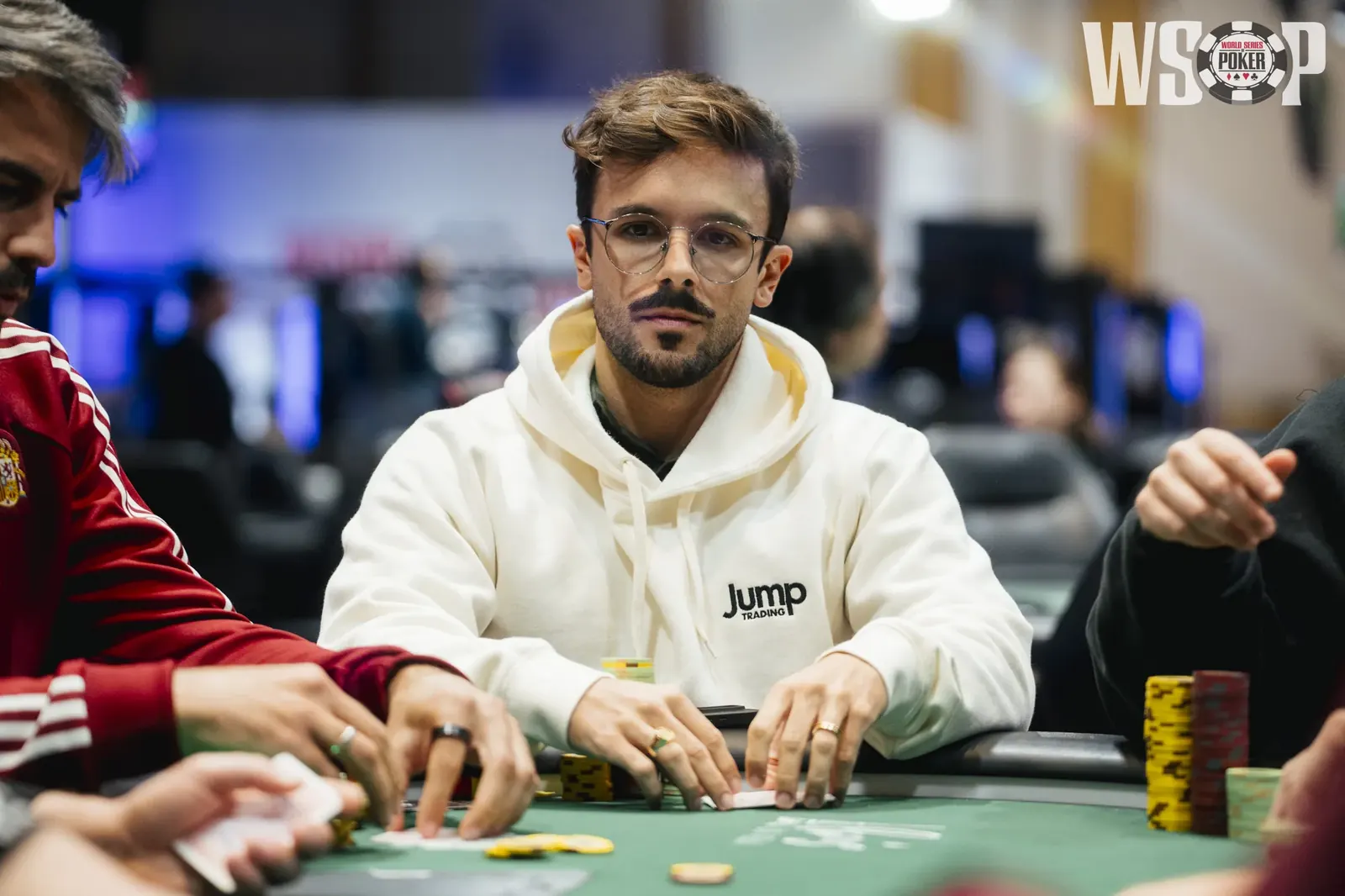 Poker players at a table during the World Series of Poker, with chips and cards visible.