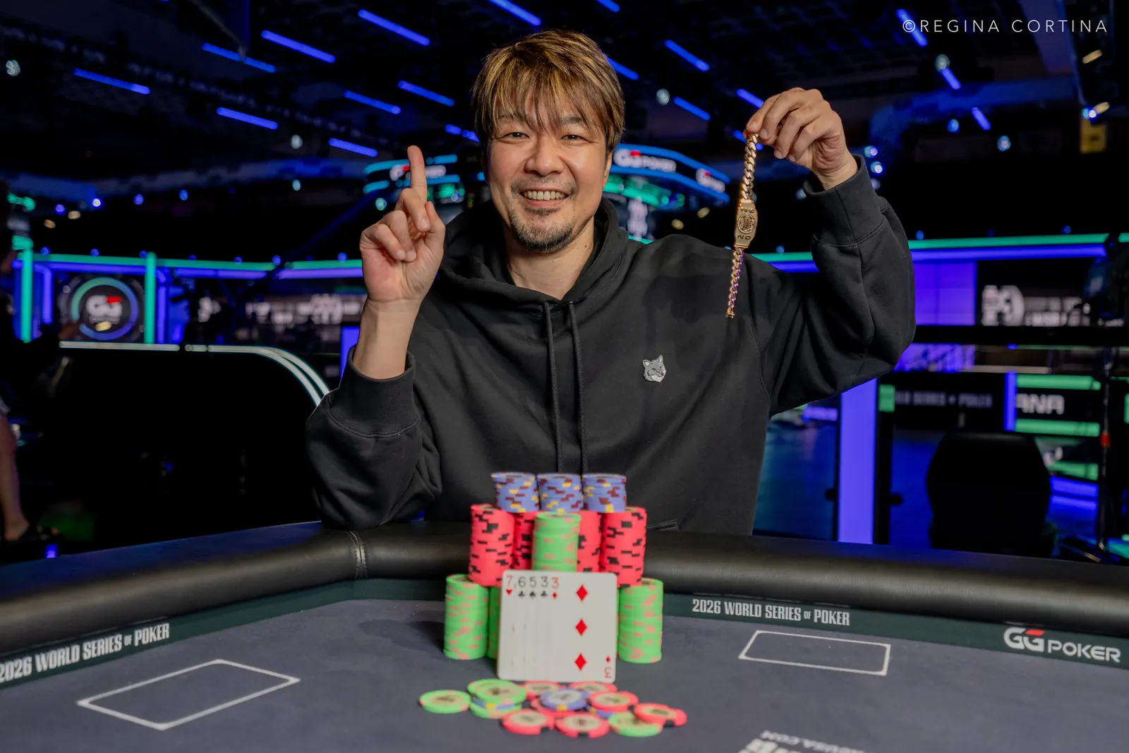 Koji Fujimoto smiling and holding up his World Series of Poker bracelet after winning the Event #67 $10,000 Limit 2-7 Triple Draw Championship.
