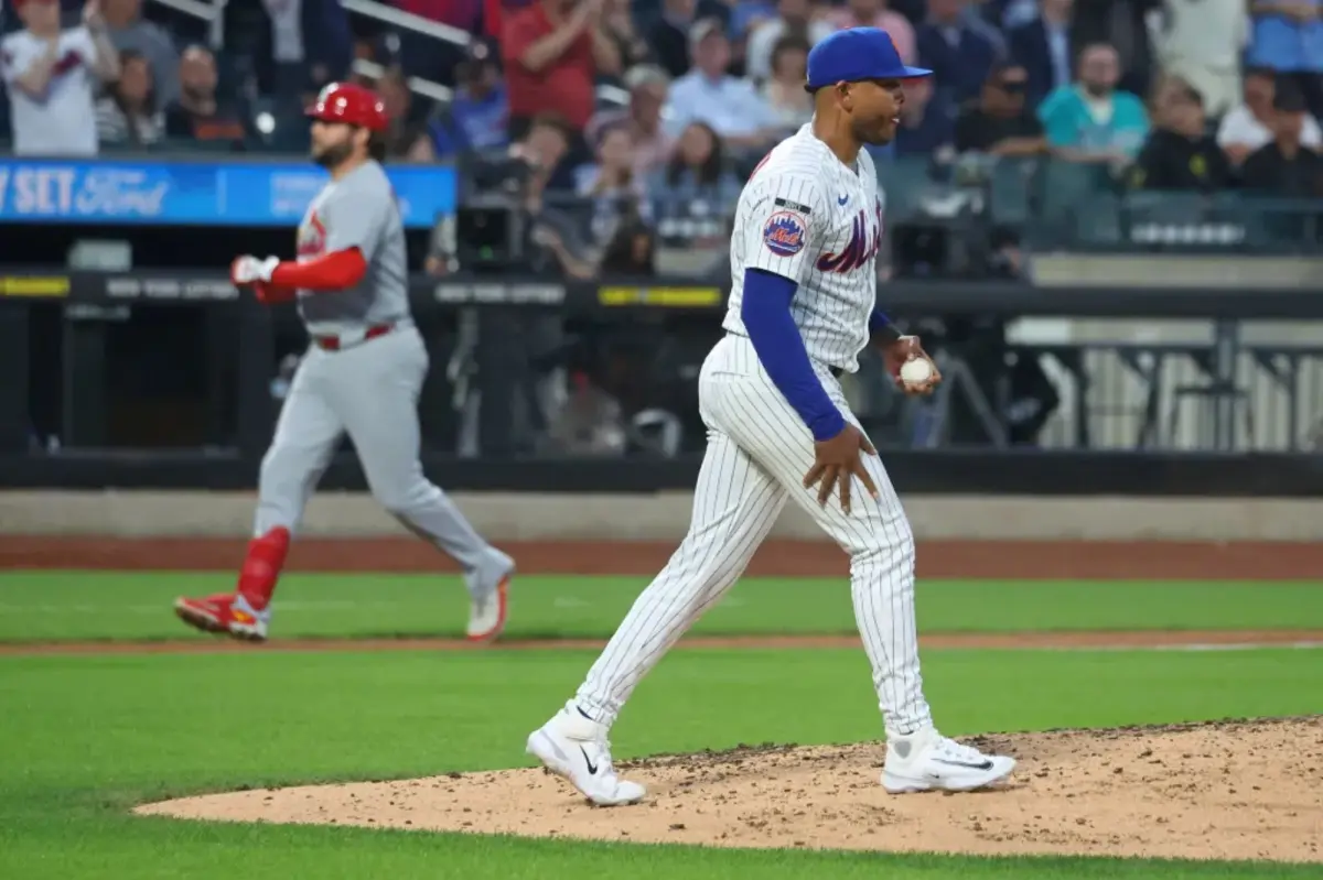 A baseball pitcher on the mound during a game.