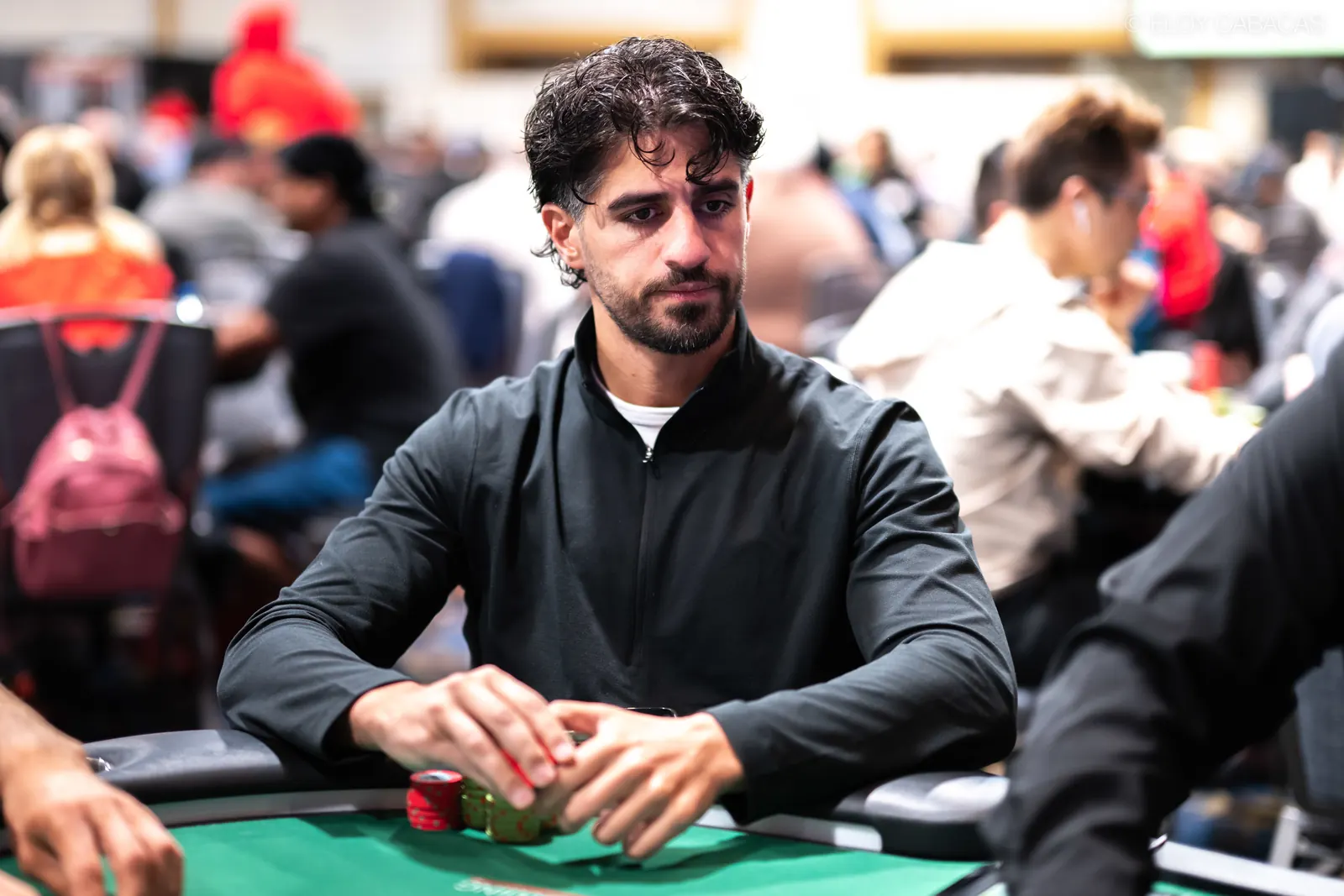 Daniel Hachem, a poker player, is pictured at a table during the World Series of Poker Main Event, focusing on his chips.