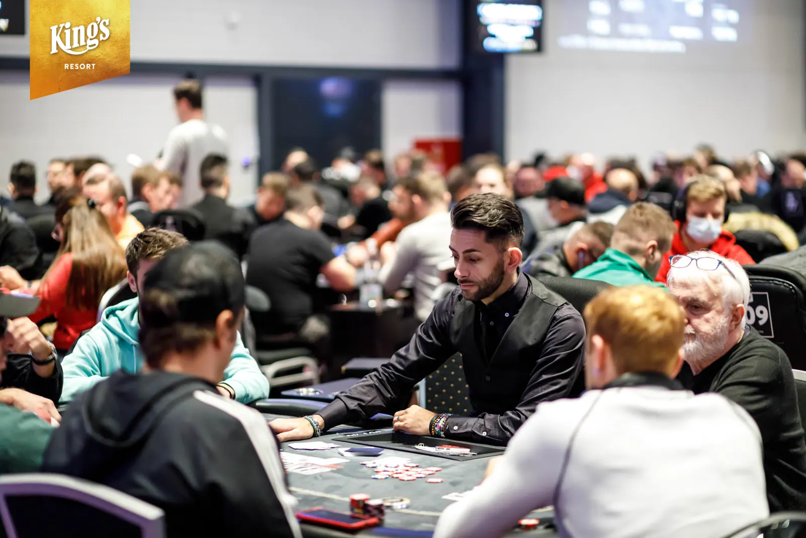 Poker players seated at tables during a tournament at King's Resort.