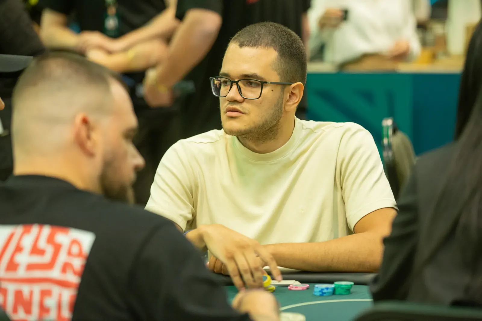 Close-up of poker chips and cards on a green felt table, highlighting a flop of Ace, Five, Deuce