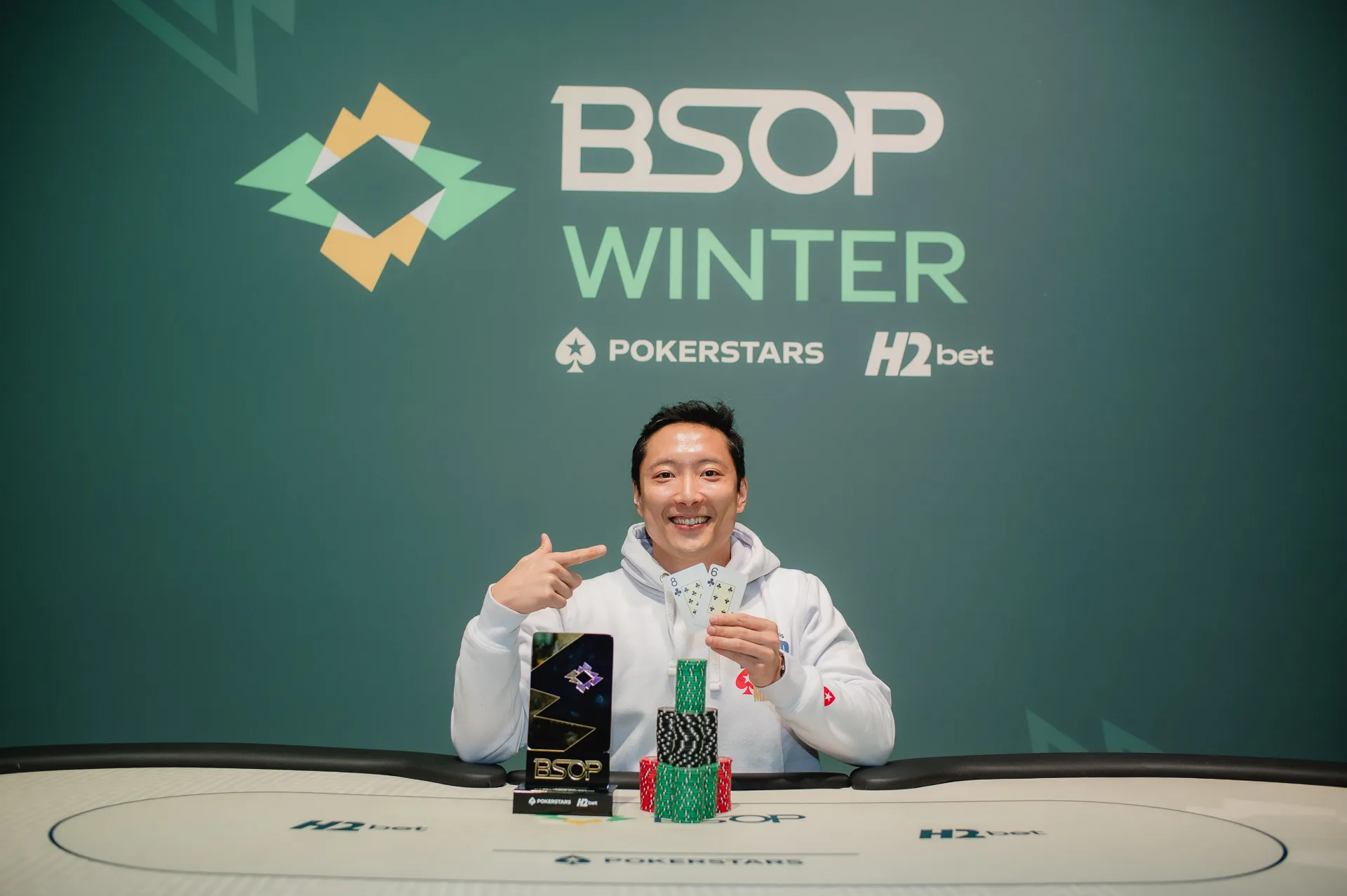 Bruno Seki holding a trophy after winning a poker tournament at BSOP Winter, Allan Souza celebrating his HORSE event victory.
