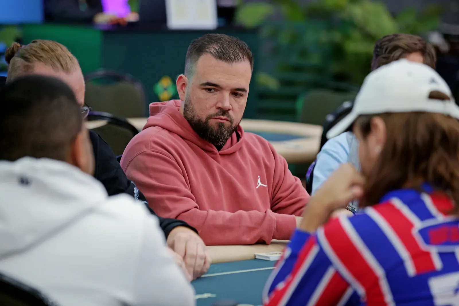 Players at a poker table during the BSOP Winter 100k Super High Roller bubble phase, with the clock and chips visible