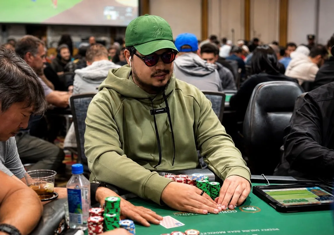 A poker player at the WSOP Main Event, surrounded by chips and cards, representing the strong Brazilian presence in the tournament.