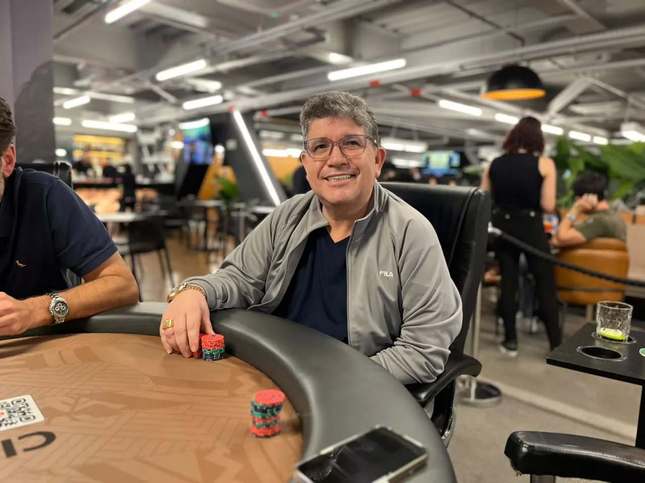 Arena Live Poker tournament in Curitiba, Brazil, with players at tables in Shopping Estação during October 2026 festival